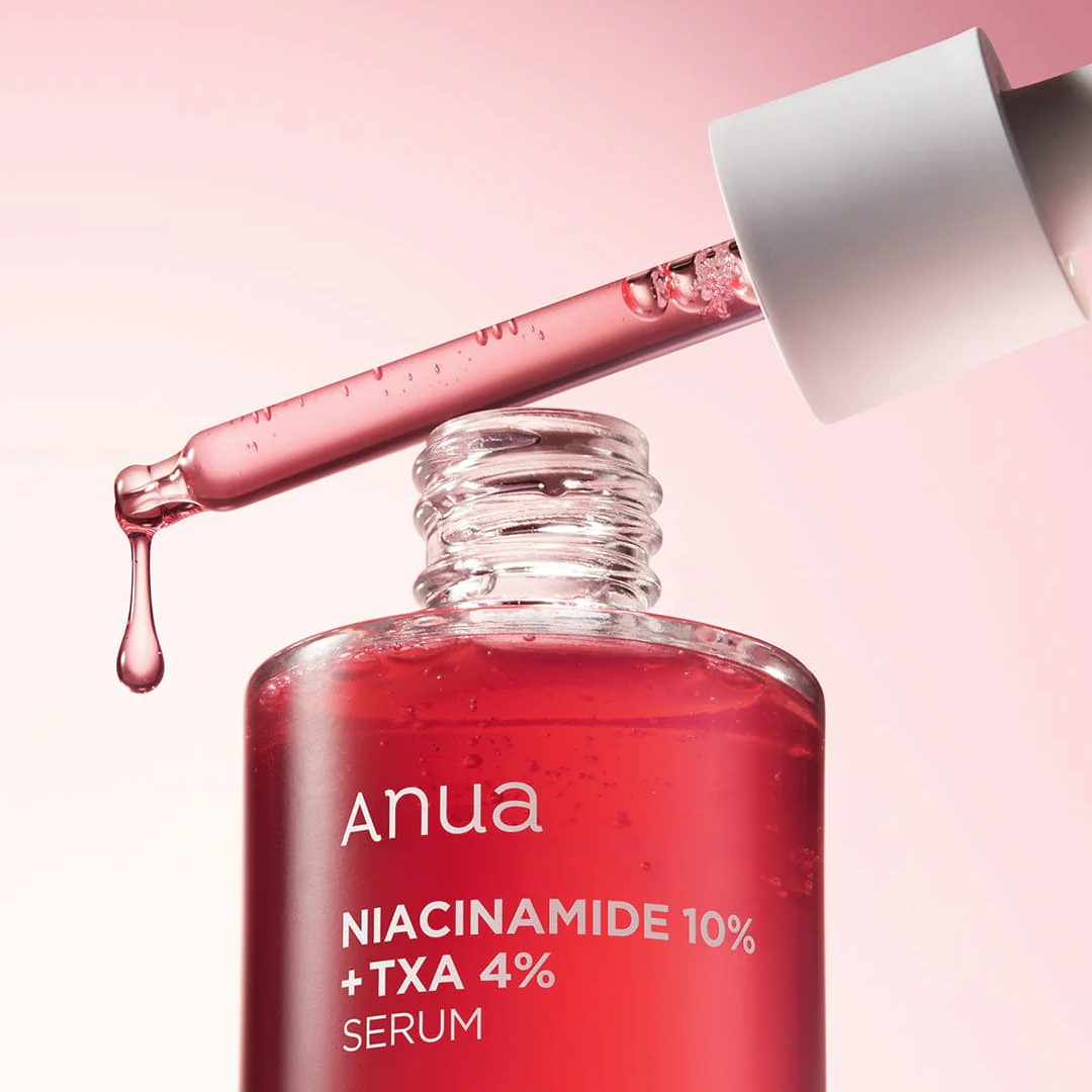 Anua Niacinamide 10% + TXA 4% serum bottle with dropper on a pink background