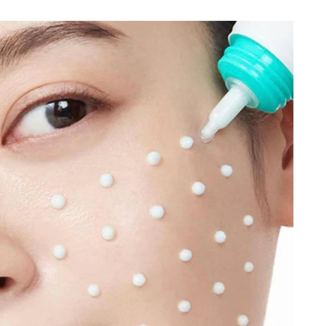 Person using a white tool with a green nozzle on their face, applying small white beads.