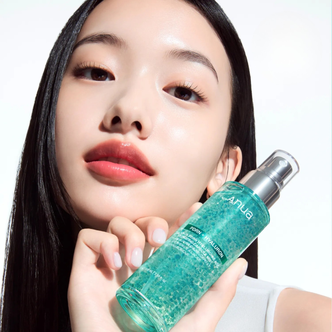 Woman holding a green skincare bottle with a blurred background